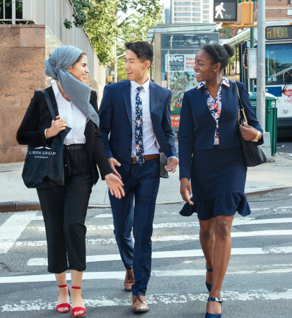 A diverse group of Libra Group employees crossing the street while having a discussion